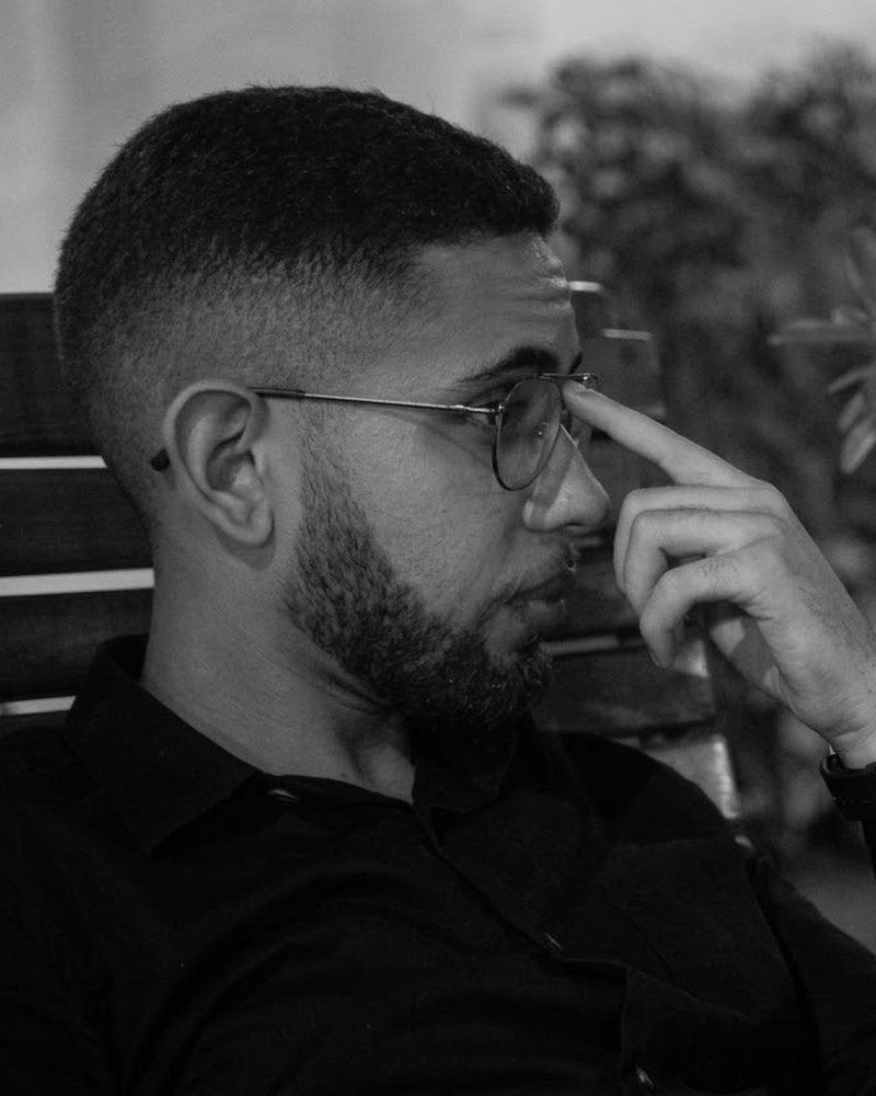 Pedro Aguilar, fundador da AXON, de perfil, com a mão no rosto, em foto preto e branco